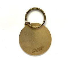 a gold colored metal key chain with a small round disc on it's end