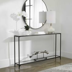 a console table with a round mirror on it