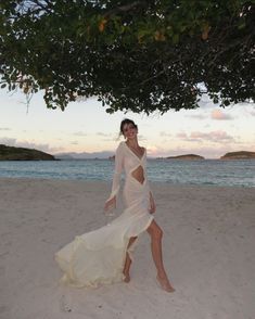 a woman in a white dress on the beach