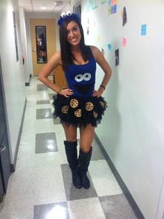 a woman in a blue shirt and black skirt posing for the camera with her hands on her hips