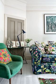 a living room filled with furniture next to a painting on the wall above a table