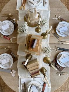 the table is set with white plates, silverware and napkins for dinner guests