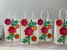 three bags with flowers on them sitting next to a toaster and paper bag holder