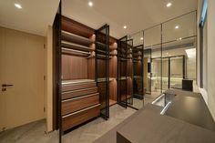 an empty walk - in closet is shown with mirrored walls and shelves on both sides