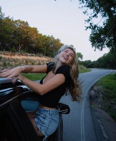 a woman leaning out the window of a car