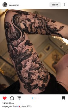 a woman's arm covered in tattoos with flowers and snakes on the back of it