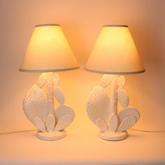 two white lamps sitting next to each other on a table