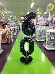 an inflatable number 6 is on the floor at a toy store with balloons