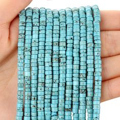 a hand holding a bunch of turquoise beads