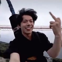 a man is holding up his peace sign in front of the camera while riding a roller coaster