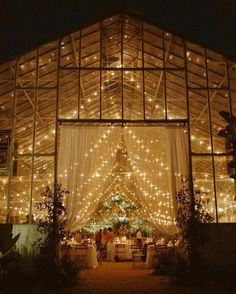 the inside of a building is lit up with fairy lights and white draping