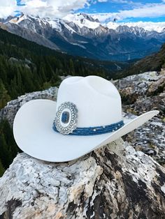 Maverick features a elegant western Lapis medallion highlighted with lapis and silver beads on a classic white canvas cowboy hat. Proudly American Made. Our hats are manufactured in Mexico and details added by hand in Los Angeles, CA using the highest quality materials. Sizing S/M 19in-22.75in | 48cm-57.5cm L/XL 19.5in-23.25in | 49.5cm-59cm *Please allow up to 6 weeks for production and shipping. Experience the luxury of the Wild West with Maverick. Lapis, a gemstone symbolizing wisdom and truth, adds a touch of timeless elegance to our design, inviting you to appreciate its unique significance and enduring beauty. Garden Party Bridal Shower, Parisian Summer, Dream Date, Bridal Fabric, The Wild West, Welcome To The Party, Hand Painted Rocks, Cowboy Hat, White Canvas