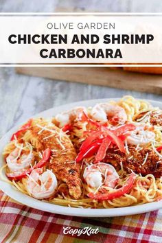 a white plate topped with pasta covered in shrimp and tomato sauce next to sliced loaves of bread