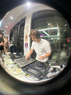 a man standing in front of a dj set up with headphones on and mixing