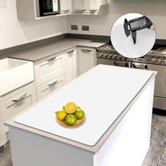 a kitchen with white cabinets and an island in front of the stove top has limes on it