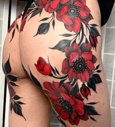 a woman's thigh with red flowers and leaves painted on the side by tattoo artist person