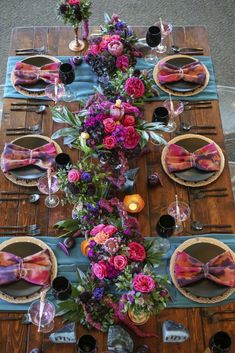 the table is set with pink and purple flowers