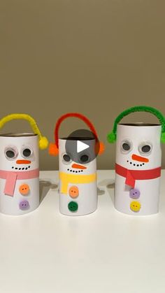 three snowmen made out of coffee cups with headphones on their ears and noses