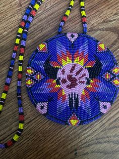 A traditional beaded medallion featuring a cow skull with a red handprint in the middle (no more stolen sisters). The whole necklace is 18 inches long and sits on a beaded rainbow chain. Multicolor Medallion Beaded Necklace For Gift, Traditional Beaded Necklace With Large Pendant And Round Beads, Multicolor Medallion Beaded Necklace As Gift, Adjustable Beaded Necklace With Large Pendant, Adjustable Medallion Beaded Necklaces For Festivals, Traditional Beaded Necklace With Large Pendant, Handmade Multicolor Medallion Beaded Necklaces, Multicolor Handmade Medallion Beaded Necklaces, Multicolor Bohemian Medallion Beaded Necklaces