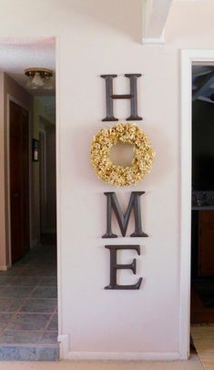 the word home is made out of metal letters with a wreath hanging from it's center