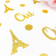 gold glitter confetti on white paper with the word out and eiffel tower