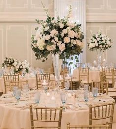 the centerpieces are arranged in tall vases with white flowers