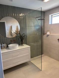 a bathroom with a sink, mirror and shower stall