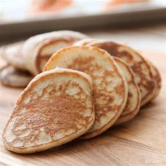 some pancakes are on a wooden table and ready to be eaten