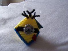 a yellow and black beaded object sitting on top of a white sheet