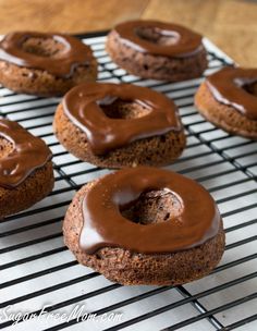 chocolate donuts with frosting on a cooling rack