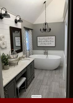 a bathroom with a tub, sink and large mirror in the middle of it's wall