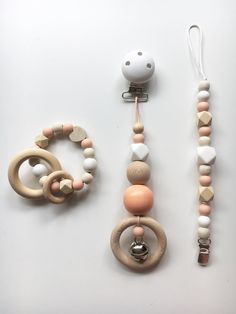 an assortment of wooden beads and rings on a white surface with a pacifier in the foreground