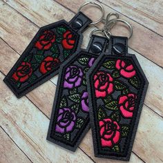 two embroidered key chains with roses on them