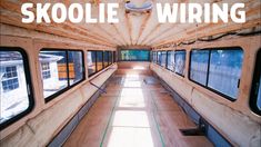 the inside of a bus with windows and wood flooring that reads skoolie wiring