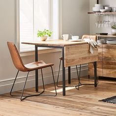 a table with two chairs next to it in front of a window