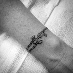 a black and white photo of a person's arm with a tattoo on it