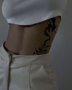 a woman's stomach with tattoos on it