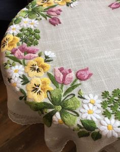 an embroidered table cloth with flowers on it