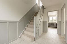 an empty hallway with stairs leading to another room