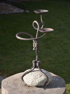 a metal candelabra sitting on top of a rock