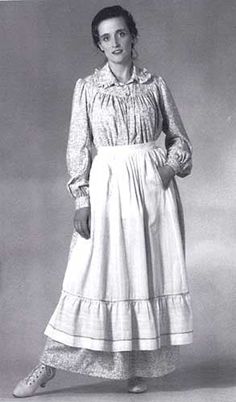 Sizes XS-3XL The stalwart women who braved the 19th century American prairie wore full yet practical housedresses of washable cotton. This flowing dress was traditionally worn with a practical apron. Ours falls to the ankles in voluminous gathers from a gracefully rounded yoke. It has long sleeves gathered at the shoulders and into buttoned cuffs. The ruffled collar is set into a collar band, and the dress has pockets set into both side seams. The deep front opening typical of this era closes wi Prairie Dress Pattern, American Prairie, Pioneer Clothing, Pioneer Dress, 1800's Dress, Pinafore Pattern, Prairie Dresses, Apron Sewing Pattern, Sewing Aprons