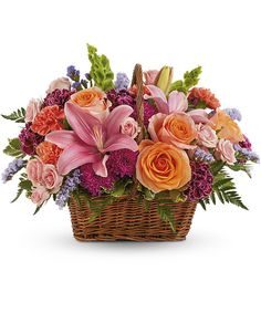 a basket filled with pink and orange flowers