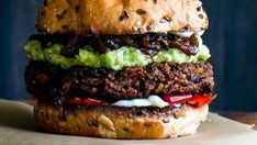 a close up of a hamburger with meat and guacamole