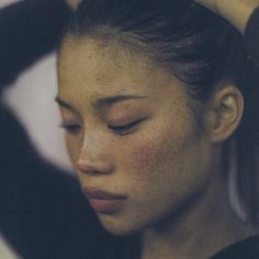 a woman with freckles on her hair is looking down