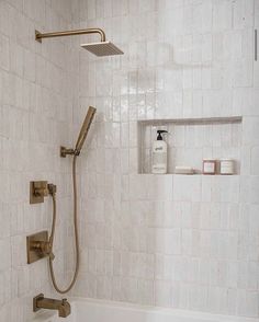 a bathroom with a tub, shower head and hand held faucet