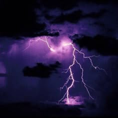 a lightning bolt is seen in the night sky above some dark clouds and purple hues