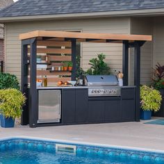 an outdoor bbq grill next to a swimming pool with potted plants on either side