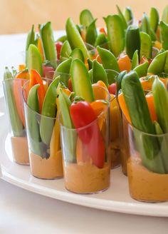 small glass cups filled with vegetables on top of a white plate