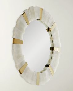 a white and gold mirror hanging on the wall