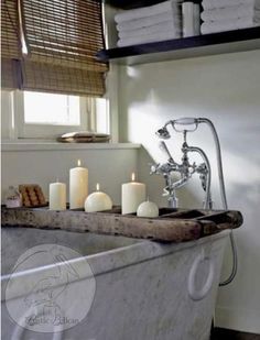 an old bathtub with candles and other items in the tub, along with towels